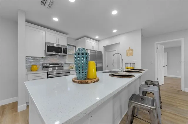 a kitchen with sink a stove and cabinets