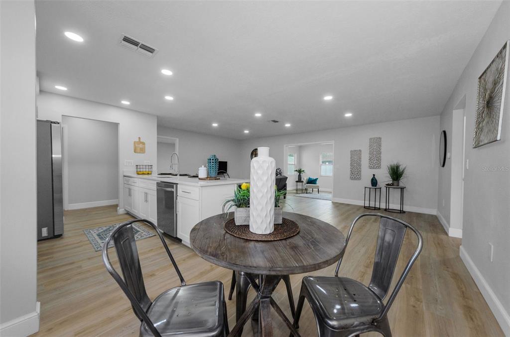 12920 Walnut Tree Lane Hudson, FL 34669 - Photo 10 of 35 a kitchen with stainless steel appliances granite countertop a dining table chairs and refrigerator