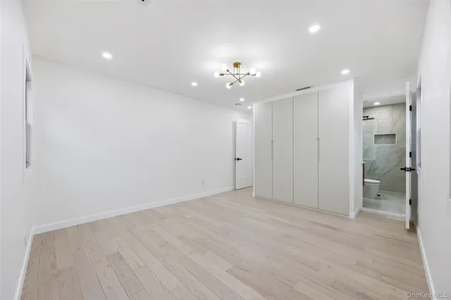wooden floor in an empty room with a bathroom
