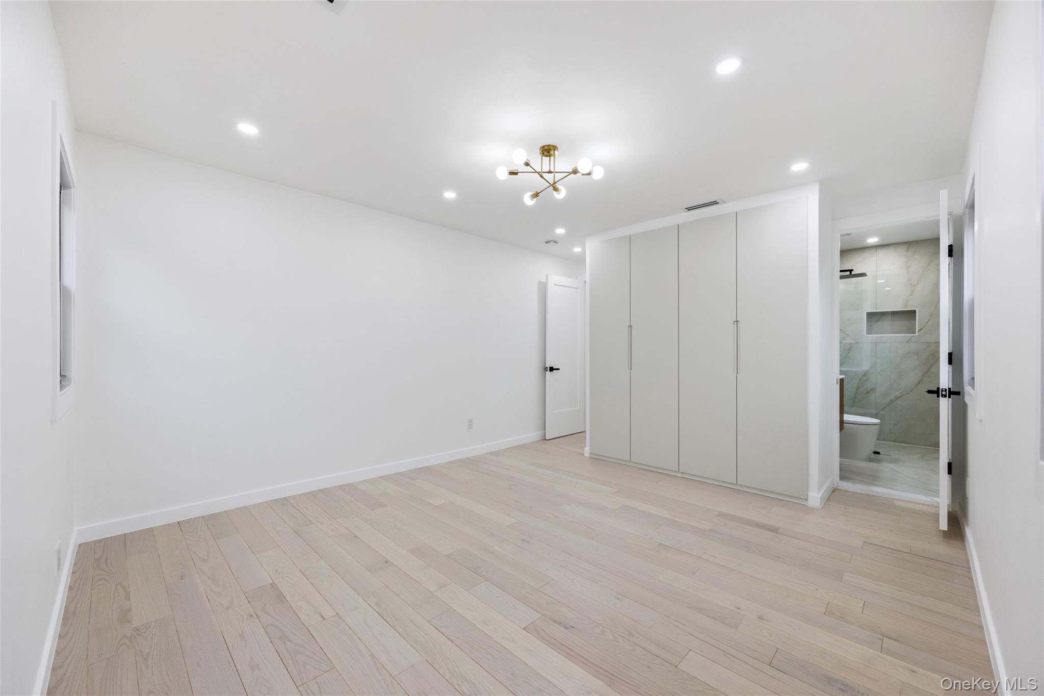 157-03 Locke Avenue Queens, NY 11357 - Photo 11 of 24 wooden floor in an empty room with a bathroom