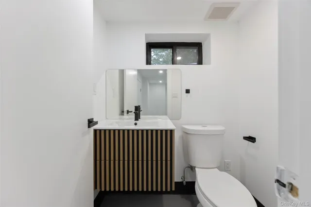 a bathroom with a toilet a sink and mirror