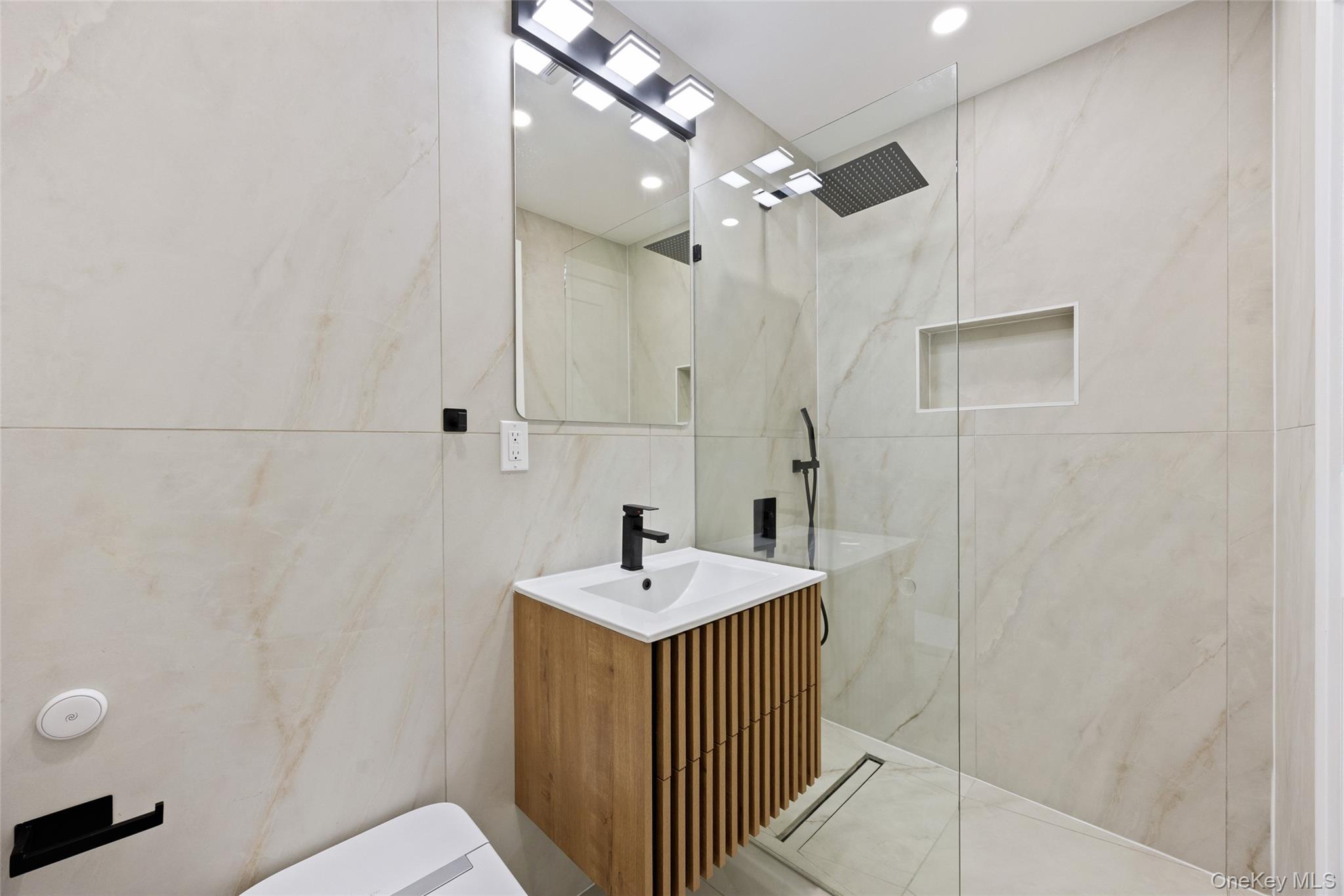 157-03 Locke Avenue Queens, NY 11357 - Photo 18 of 24 a bathroom with a sink a mirror and shower