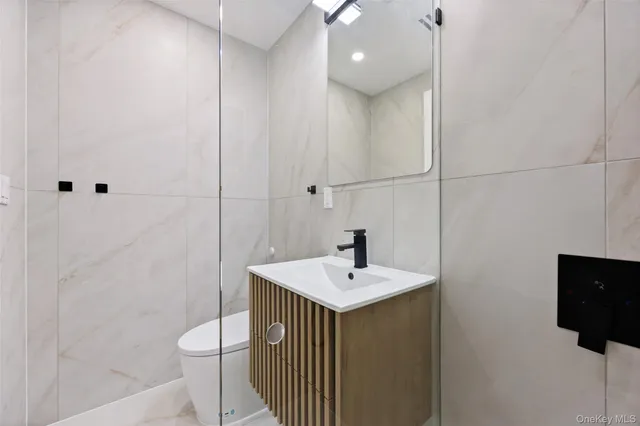 a bathroom with a sink a toilet and mirror