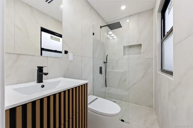 a bathroom with a sink toilet a mirror and shower