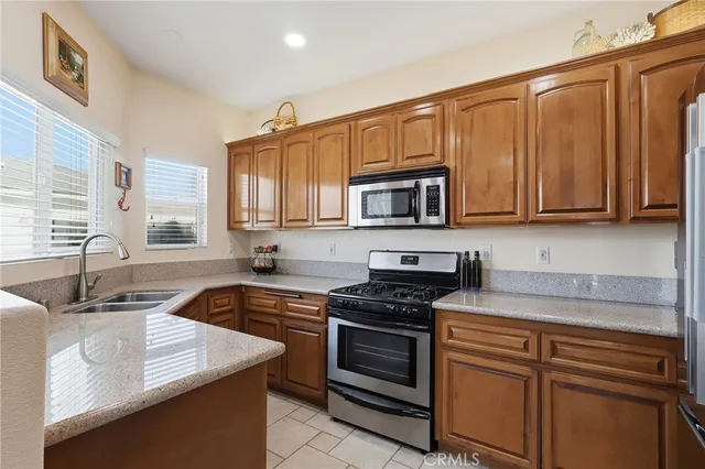 a kitchen with stainless steel appliances granite countertop a sink stove and microwave