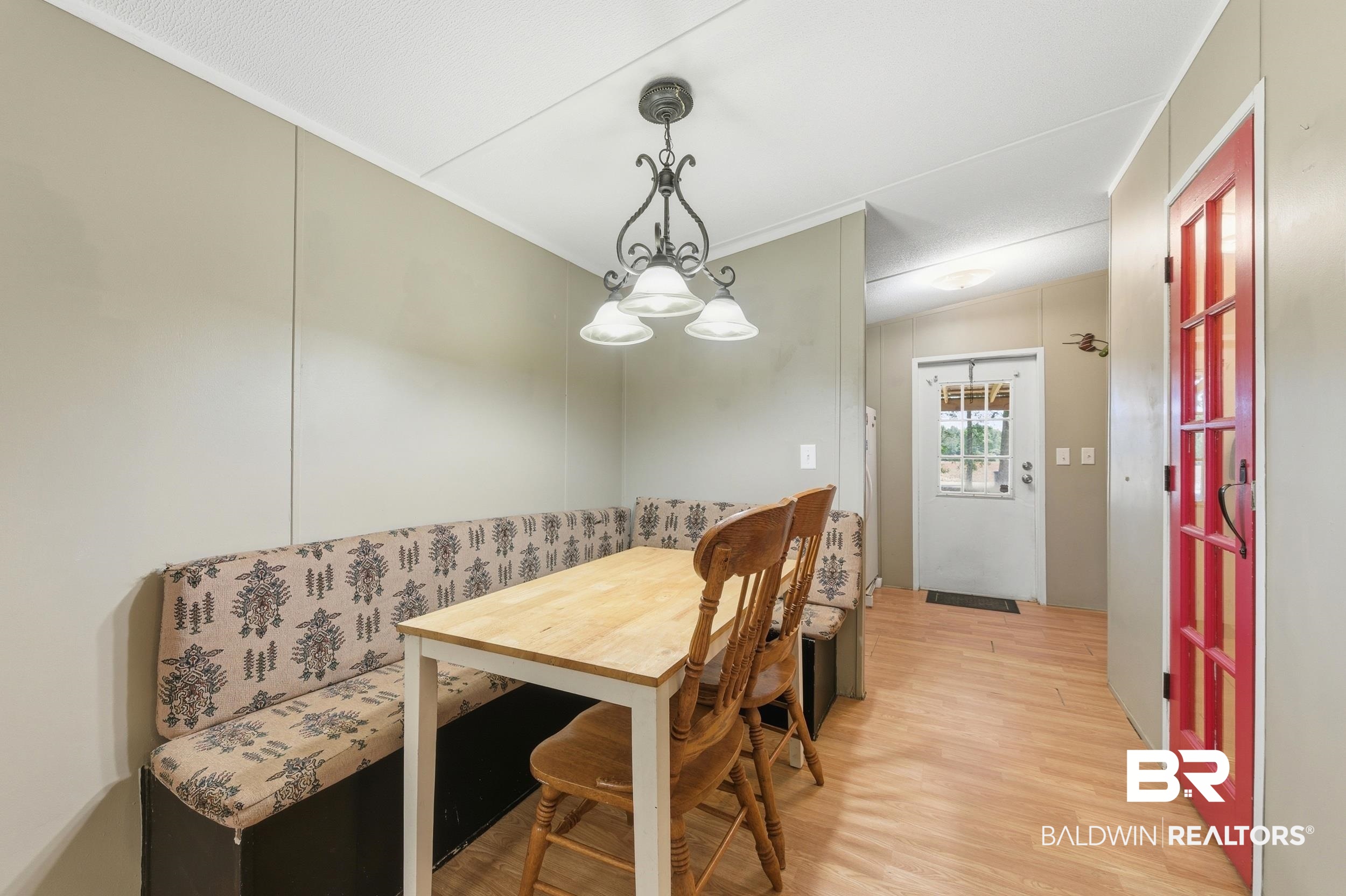 926 Tumbling Lane Atmore, AL 36502 - Photo 22 of 56 Dining area featuring a built-in bench, wood-finish flooring, and a decorative pendant light fixture