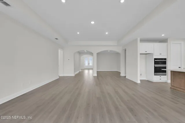 an empty room with entrance and windows