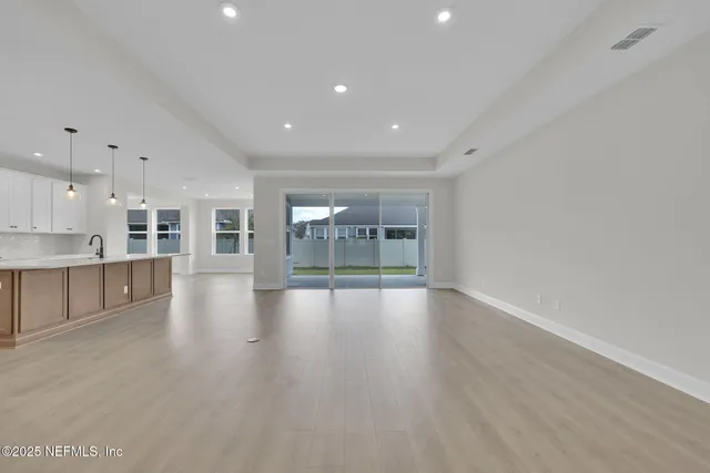 a view of a kitchen with furniture and wooden floor