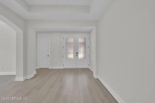 a view of an empty room with wooden floor and closet