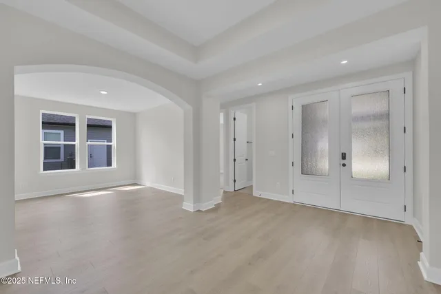 a view of empty room with wooden floor and window
