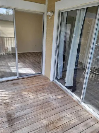 an empty room with wooden floor and entrance