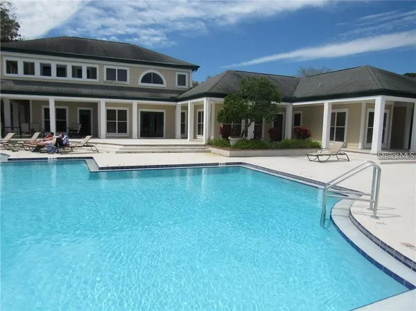 a view of house with swimming pool and porch