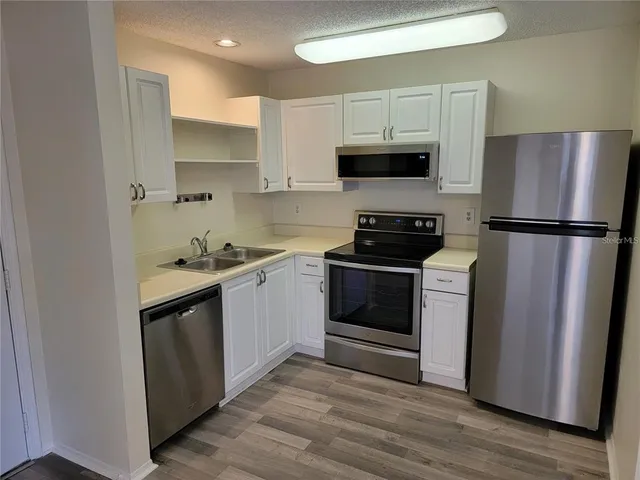 a kitchen with stainless steel appliances a refrigerator stove and microwave