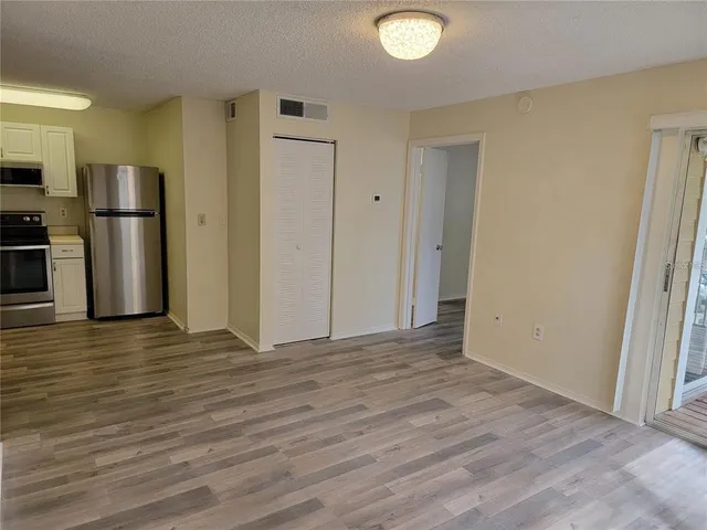 a view of empty room with wooden floor