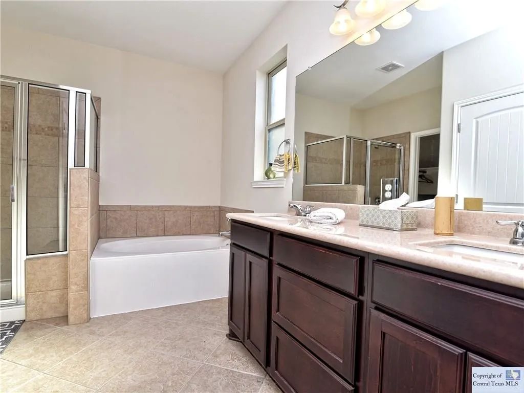 3029 Jacob Lane San Marcos, TX 78666 - Photo 12 of 24 a bathroom with a bathtub double sink and a mirror
