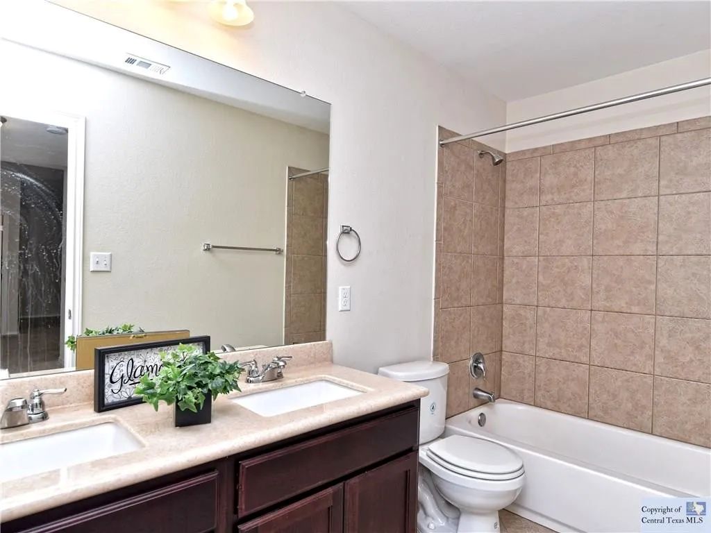 3029 Jacob Lane San Marcos, TX 78666 - Photo 16 of 24 a bathroom with a sink a toilet a mirror and shower