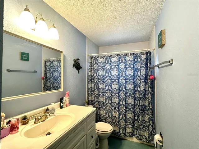 a bathroom with a toilet and a shower curtain