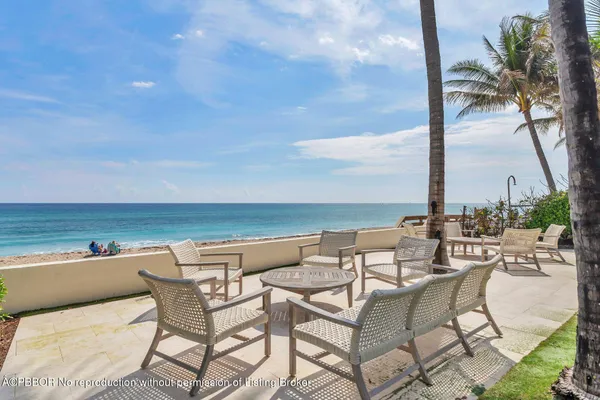 an outdoor space with chairs and ocean view
