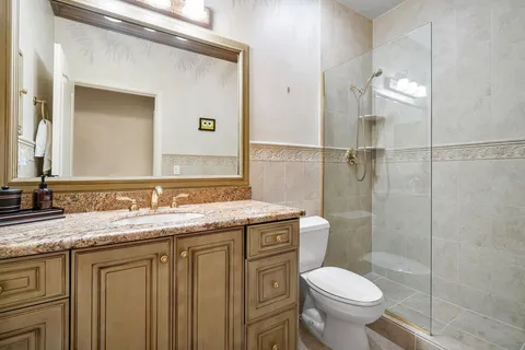 a bathroom with a granite countertop sink toilet and shower