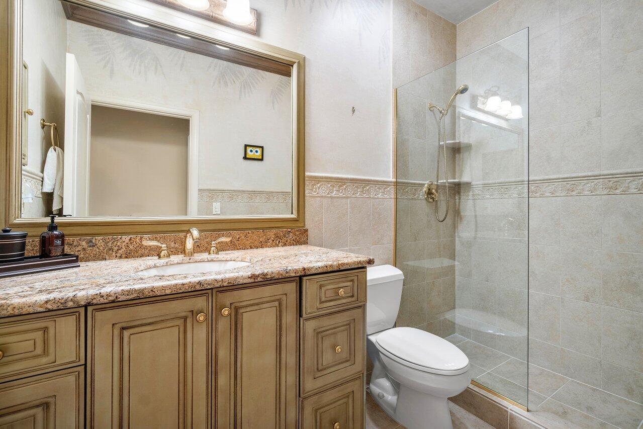 8161 Quail Meadow Way West Palm Beach, FL 33412 - Photo 15 of 36 a bathroom with a granite countertop sink toilet and shower