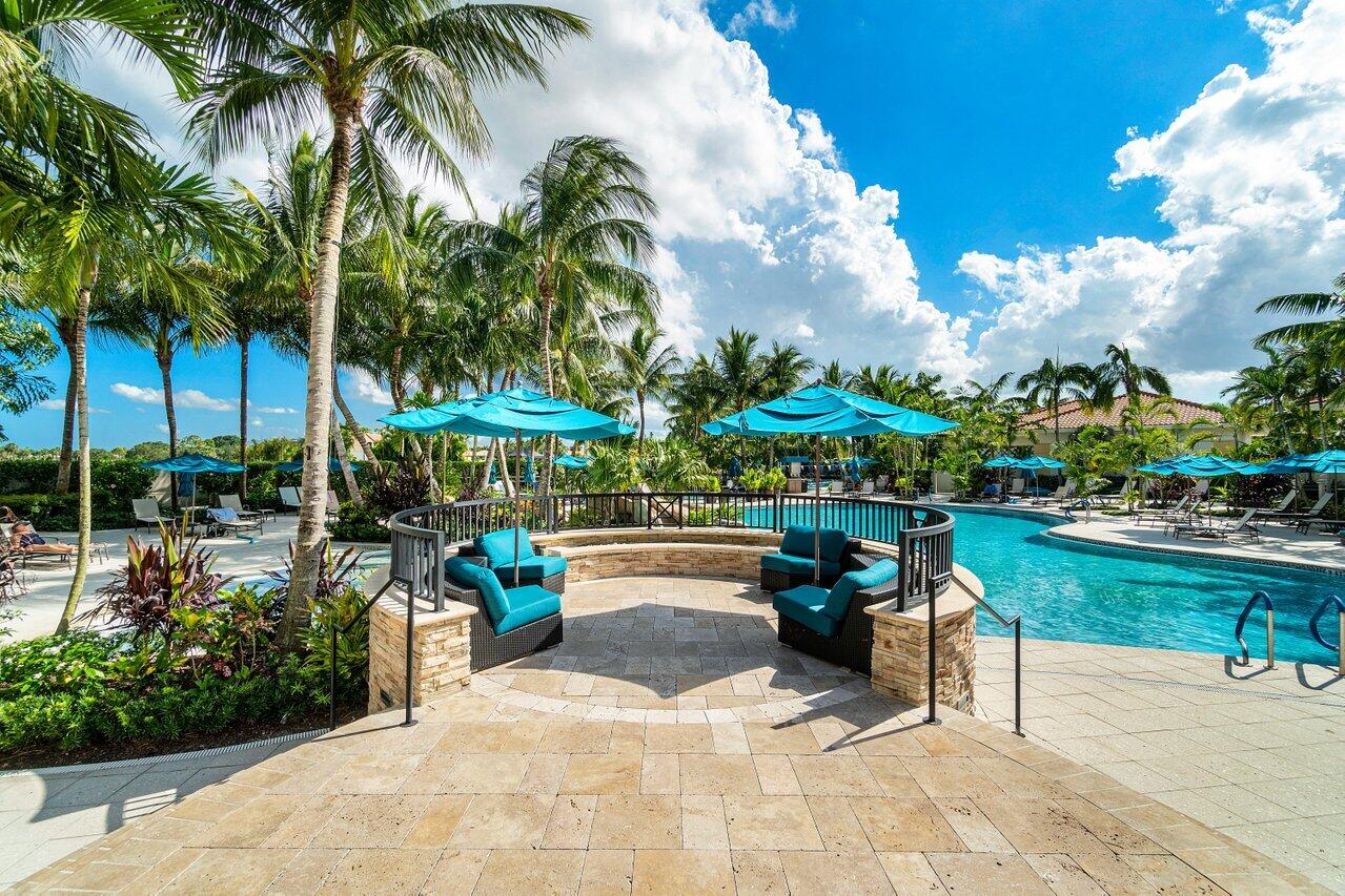 8161 Quail Meadow Way West Palm Beach, FL 33412 - Photo 30 of 36 a view of a patio with a table and chairs under an umbrella