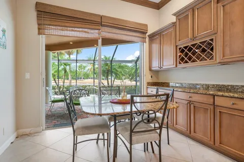 a view of a dining room with furniture a chandelier and kitchen view