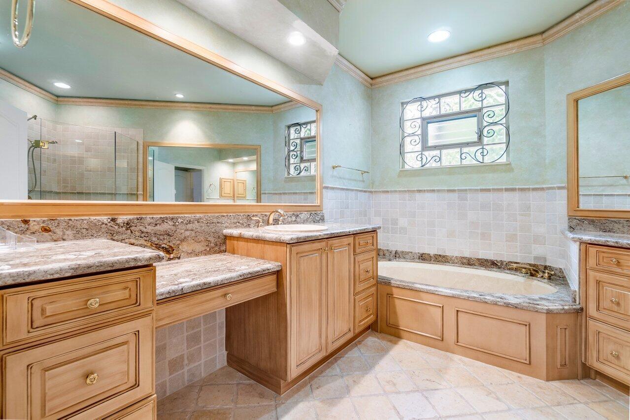 8161 Quail Meadow Way West Palm Beach, FL 33412 - Photo 9 of 36 a bathroom with a granite countertop sink a mirror and a bathtub