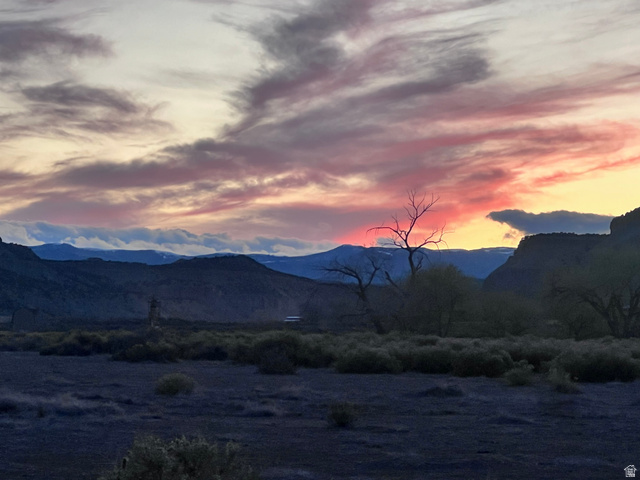 2815 Gordon Creek Road Price, UT 84501 - Photo 10 of 13 Expansive landscape featuring distant mountains, a prominent sunset with vibrant cloud formations, and varied terrain with sparse vegetation