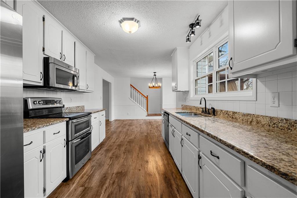 3048 Turner Church Road McDonough, GA 30252 - Photo 11 of 57 a kitchen with granite countertop a sink a counter space stainless steel appliances and cabinets