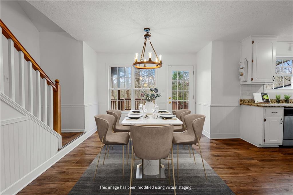 3048 Turner Church Road McDonough, GA 30252 - Photo 13 of 57 a dining room with wooden floor a chandelier a wooden table and chairs