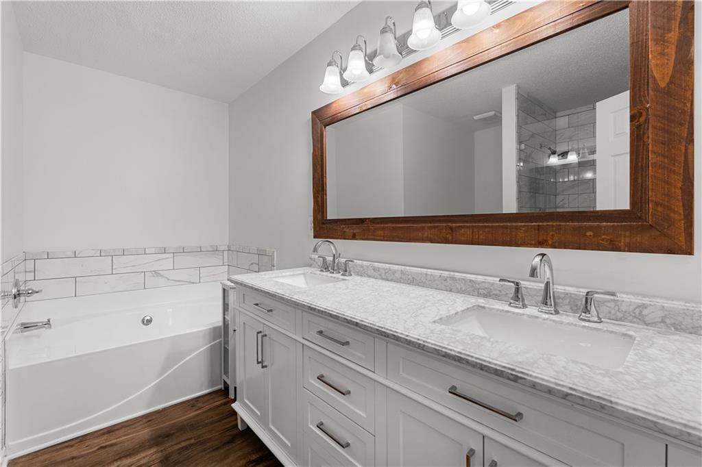 3048 Turner Church Road McDonough, GA 30252 - Photo 21 of 57 a bathroom with a granite countertop bathtub a double vanity sink and mirror