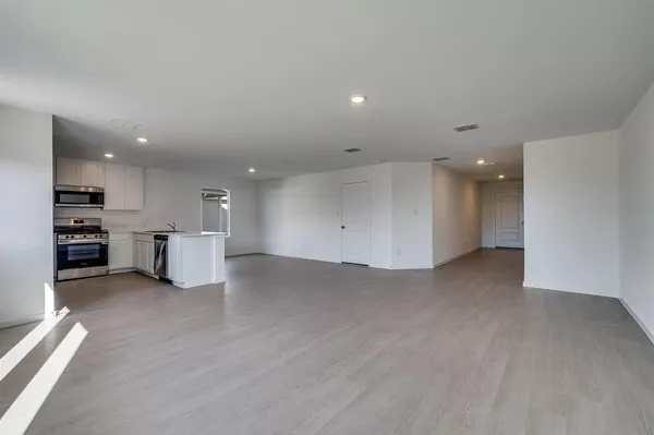 a view of kitchen with refrigerator and white cabinets