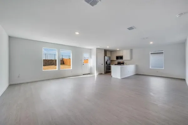a view of a kitchen with a sink stove cabinets and empty room