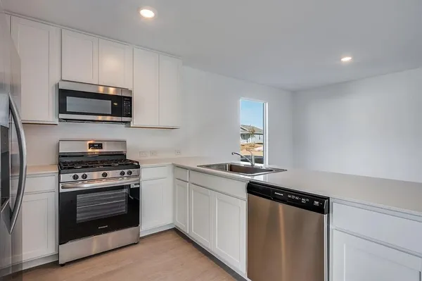 a kitchen with granite countertop a stove and a microwave