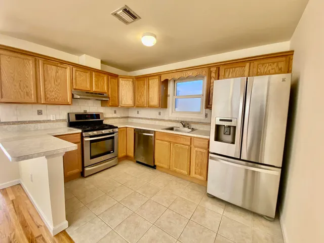a kitchen with white cabinets stainless steel appliances and a window