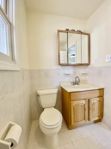 a bathroom with a toilet sink and mirror