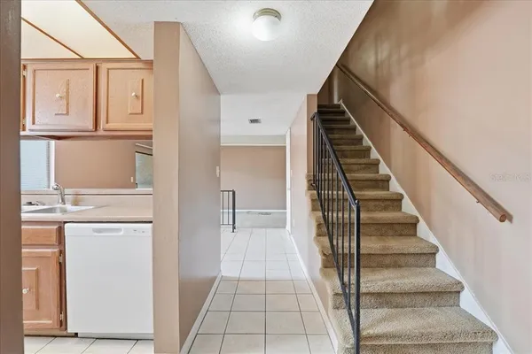 a view of a hallway with wooden floor and staircase