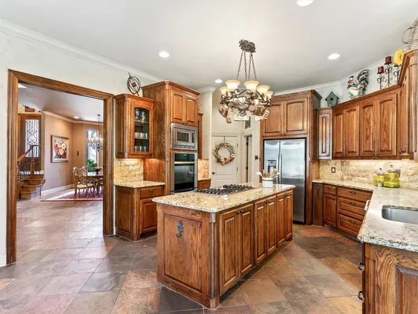 a kitchen with a stove a sink a dining table and chairs