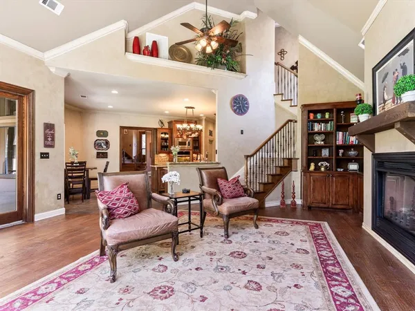 a living room with furniture a fireplace and a chandelier