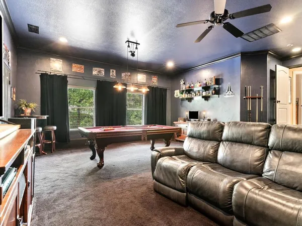 a room with pool table and windows