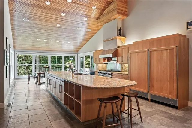 a large dining hall with stainless steel appliances granite countertop a stove and cabinets