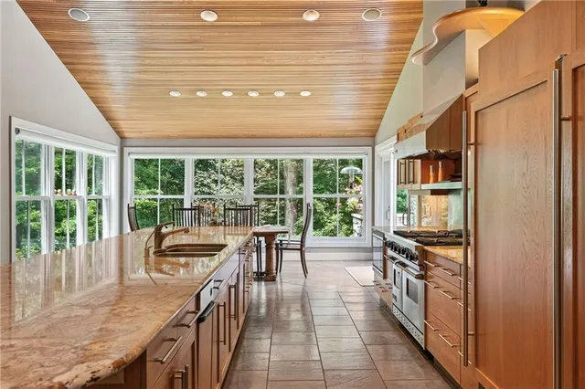 a open kitchen with granite countertop a stove a sink and cabinets