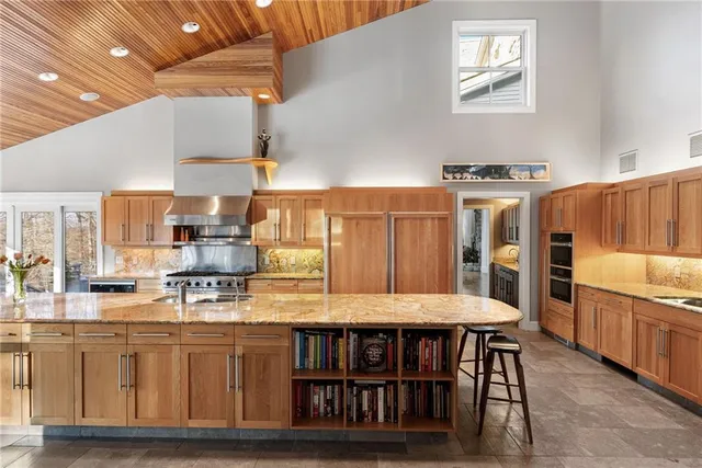 a kitchen with stainless steel appliances granite countertop a stove a sink and a refrigerator