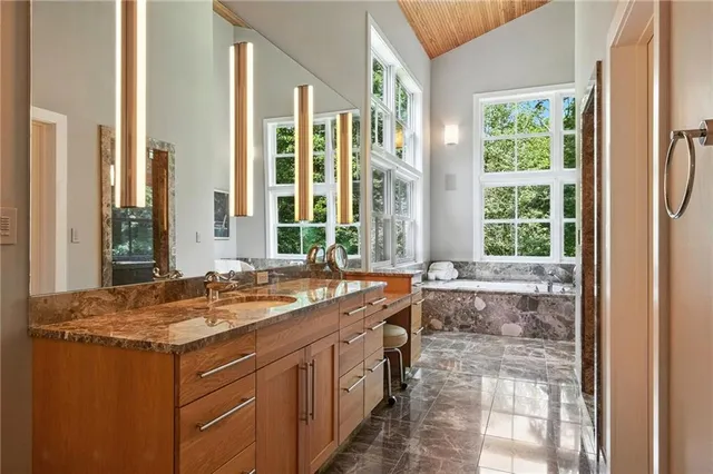 a bathroom with a granite countertop sink and a large mirror