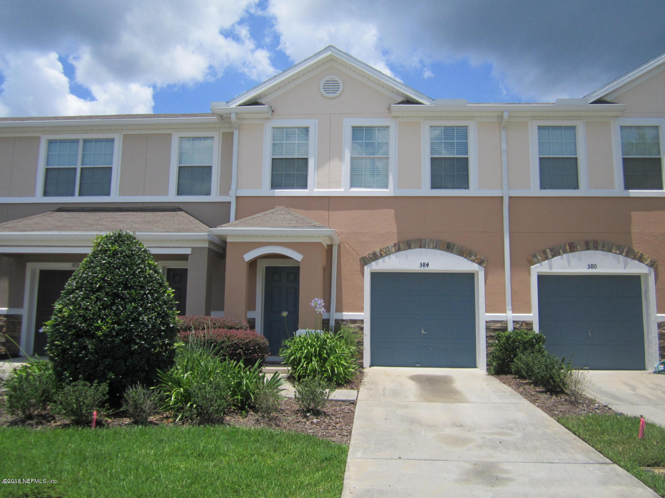 a front view of a house with a yard and a garage