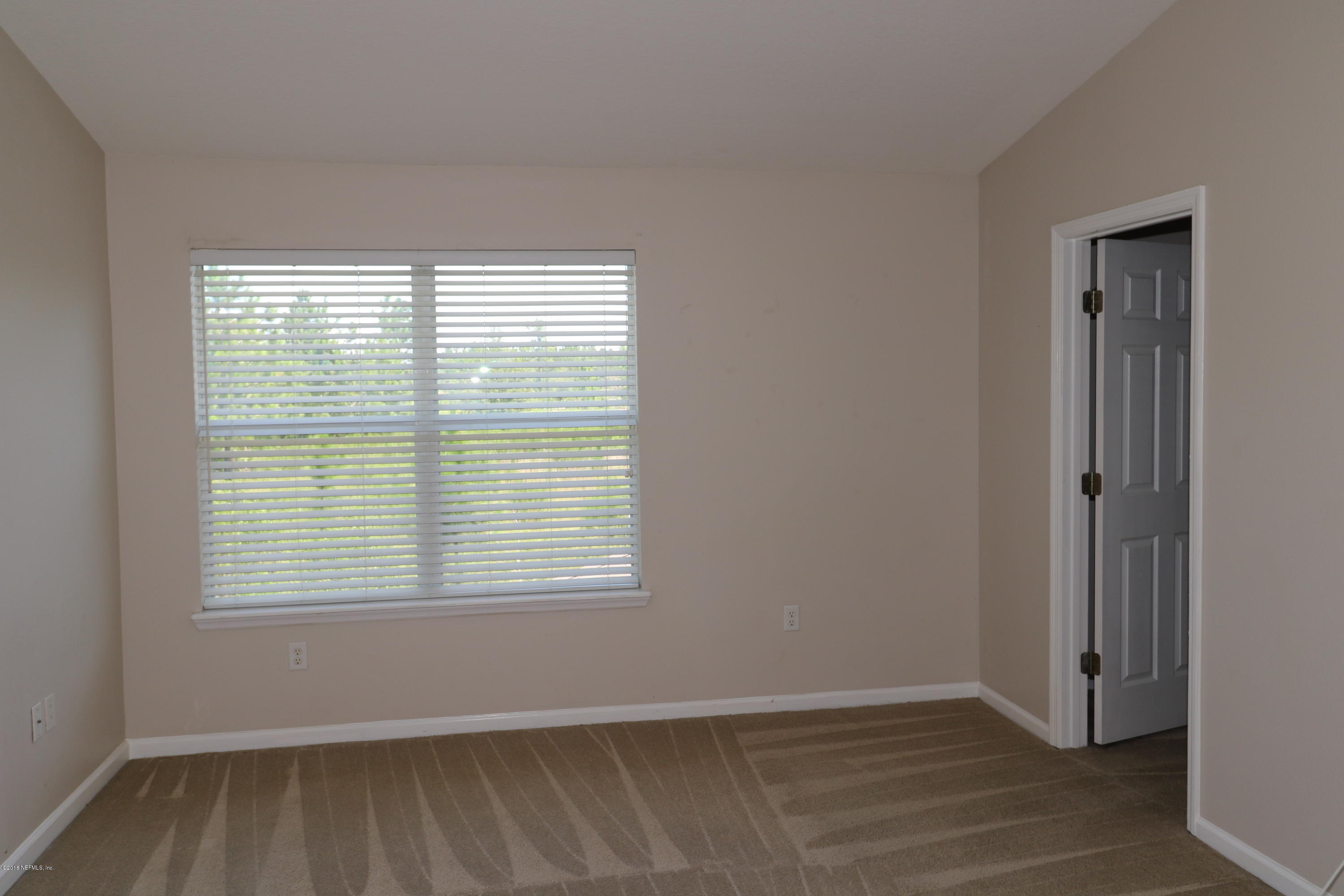 584 Crystal Way Orange Park, FL 32065 - Photo 11 of 14 a view of an empty room with wooden floor and a window