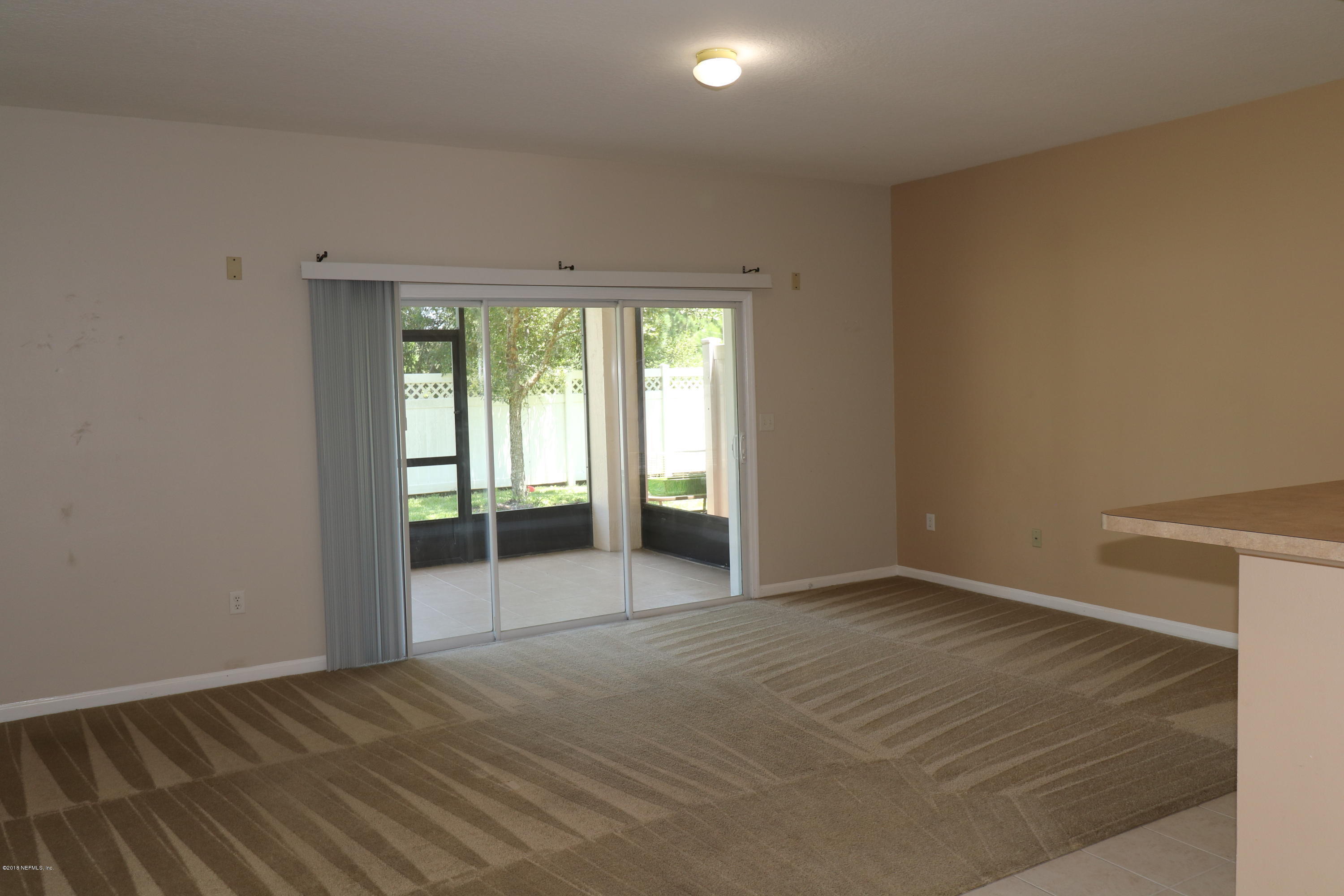 584 Crystal Way Orange Park, FL 32065 - Photo 14 of 14 an empty room with wooden floor and sliding door