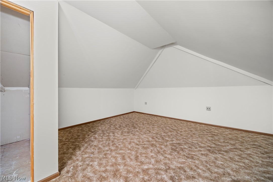 51488 Peck Wadsworth Road Wellington, OH 44090 - Photo 44 of 50 Attic space featuring sloped ceilings, light-colored walls, and patterned carpeting
