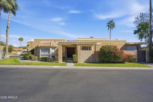 a view of a house with a big yard and palm trees