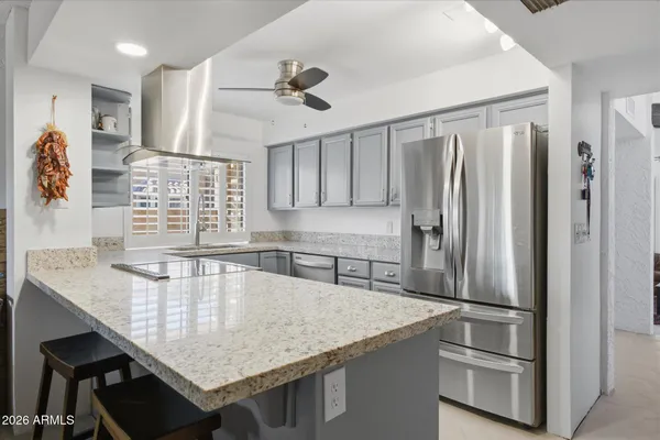 a kitchen with stainless steel appliances granite countertop a sink refrigerator and microwave